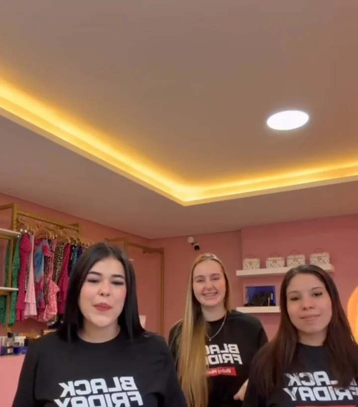 Tres chicas del equipo de Ruby Modas con remeras de Black Friday adentro del local